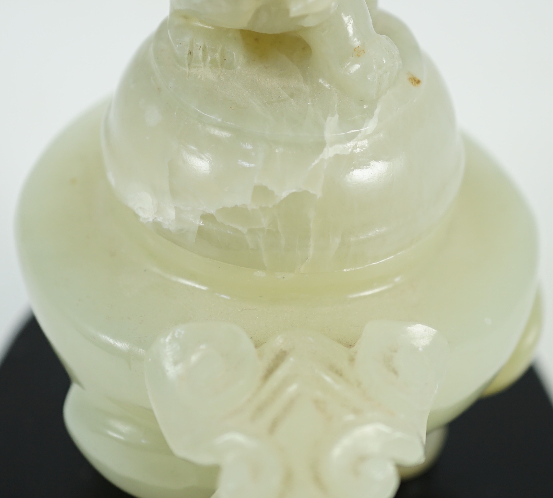 A Chinese pale celadon jade tripod censer cover, 20th century, 12cm wide, wood stand